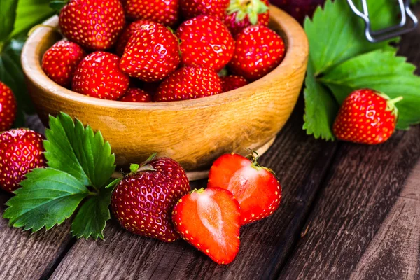 Fragola su fondo legno. Fragola con flusso di foglie verdi — Foto Stock