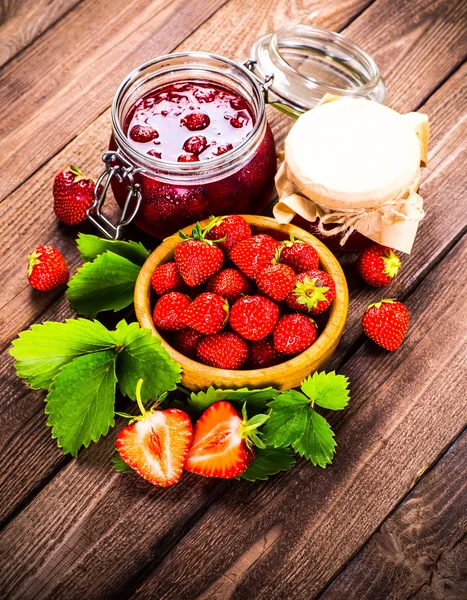 Fragola su fondo legno. Fragola con flusso di foglie verdi — Foto Stock