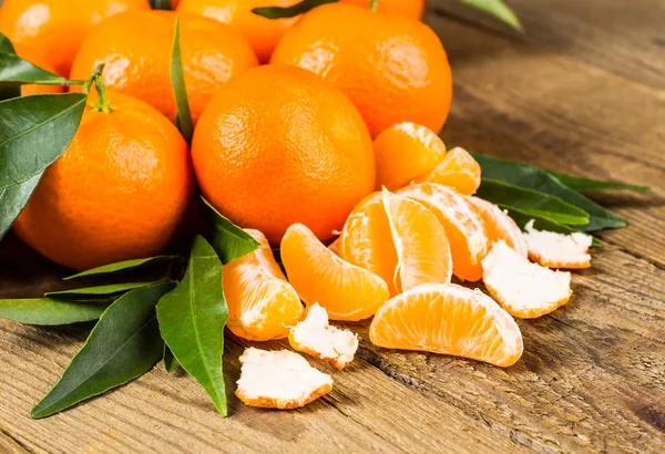 Ripe Mandarin fruit peeled open and place on old rustic look tim — Stock Photo, Image