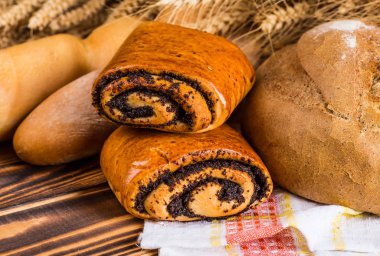 Ahşap masa arkasında pişmiş ekmek çeşitleri