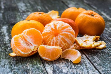 Olgun Mandarin meyve açık soyulmuş ve eski rustik etrafa tim
