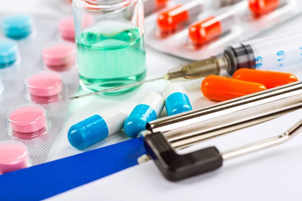 Estetoscópio, comprimidos e garrafas sobre fundo de cor. medicina con — Fotografia de Stock