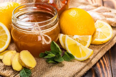 Bal tarak, taze limon ve zencefil ahşap bir masa üzerinde