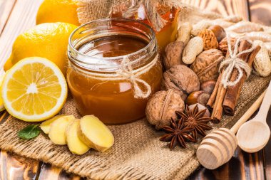 Bal tarak, taze limon ve zencefil ahşap bir masa üzerinde