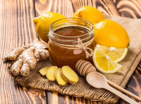 Honey comb, fresh lemon and ginger on a wooden table — Stock Photo, Image