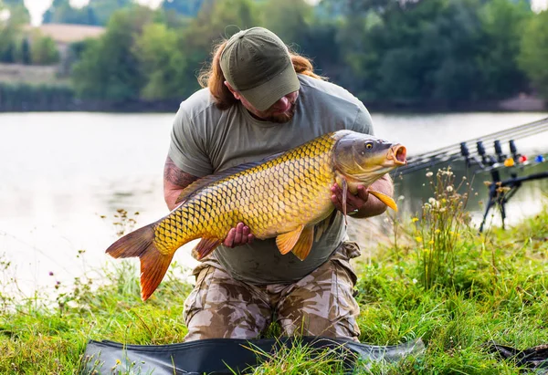 Carpe et pêcheur, trophée de pêche à la carpe . — Photo