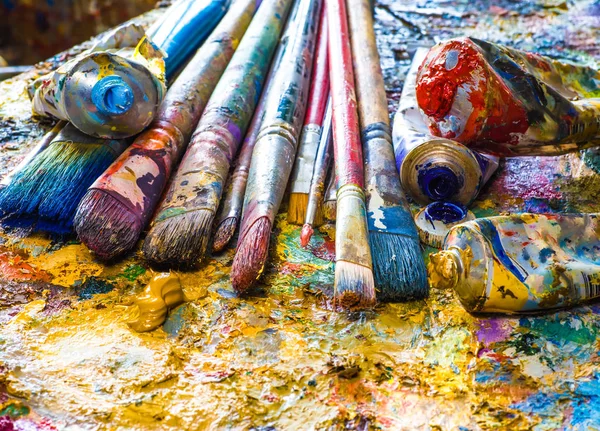 Oljefärger och målar borstar på en palett — Stockfoto