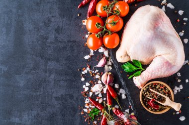 koyu arka plan üzerinde sebze ile taze çiğ tavuk budu