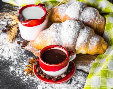 Siyah arka planda kahve ve kruvasan.