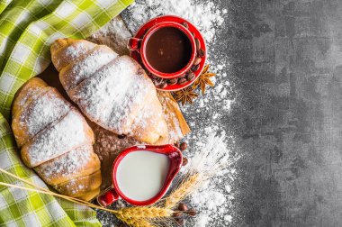 Siyah arka planda kahve ve kruvasan.