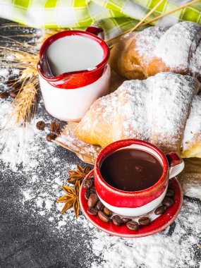 Siyah arka planda kahve ve kruvasan.