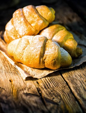 Eski ahşap masada lezzetli tereyağlı kruvasanlar..