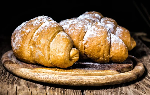 Croissants amanteigados saborosos na mesa de madeira velha. — Fotografia de Stock