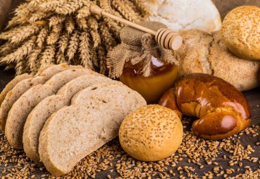 Ahşap masa arkasında pişmiş ekmek çeşitleri