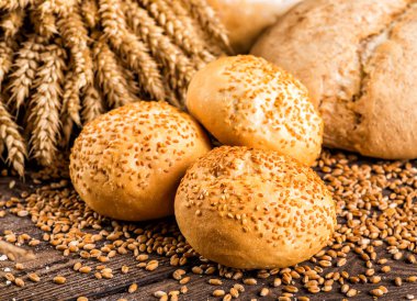 Ahşap masa arkasında pişmiş ekmek çeşitleri