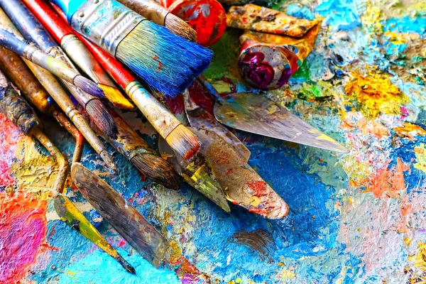 Målarfärg och penslar, liggande på målade bakgrunden — Stockfoto