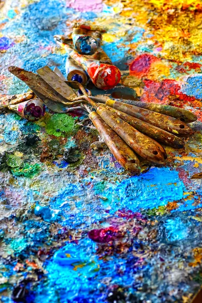Tintas e escovas, deitado sobre fundo pintado — Fotografia de Stock