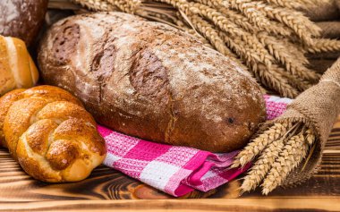 Ahşap masa arkasında pişmiş ekmek çeşitleri