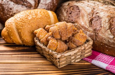 Ahşap masa arkasında pişmiş ekmek çeşitleri