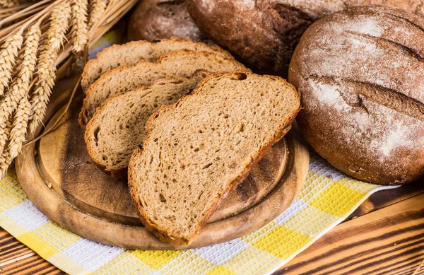 Assortment of baked bread on wooden table background — Stock Photo, Image