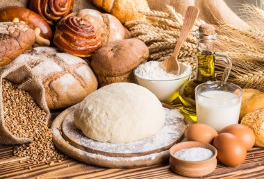 Ahşap masa arkasında pişmiş ekmek çeşitleri