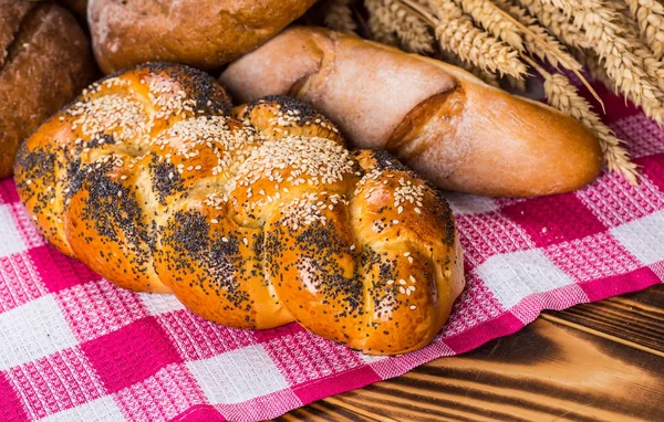 Assortment of baked bread on wooden table background — Stock Photo, Image