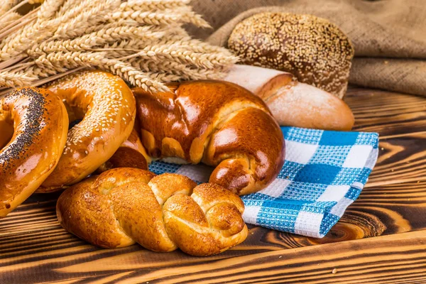 Assortment of baked bread on wooden table background — Stock Photo, Image