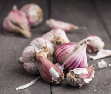 Organik sarımsak. Sarımsak basın. Menekşe sarımsak. Ahşap tahta.