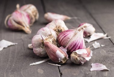 Organik sarımsak. Sarımsak basın. Menekşe sarımsak. Ahşap tahta.