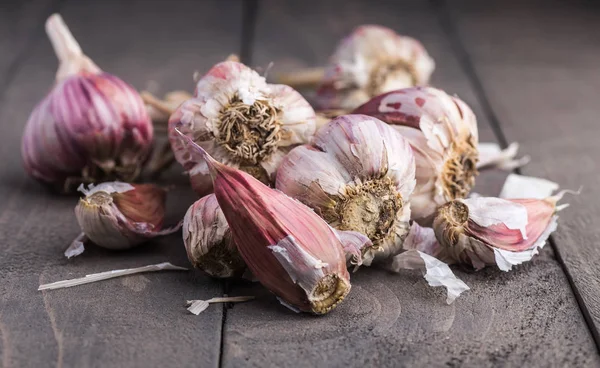 Organic garlic. Garlic press. Violet garlic.Wooden board.