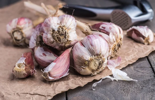 Organic garlic. Garlic press. Violet garlic.Wooden board.