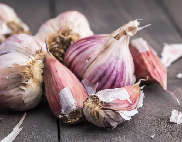 Organic garlic. Garlic press. Violet garlic.Wooden board.