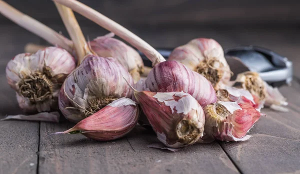 Organic garlic. Garlic press. Violet garlic.Wooden board.