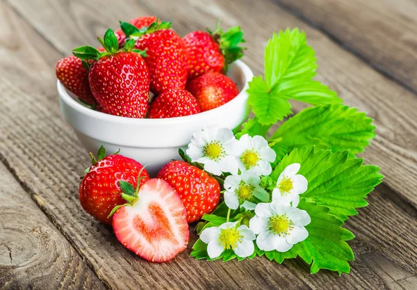 Fresh strawberries in a bowl on wooden table. — Stock Photo, Image