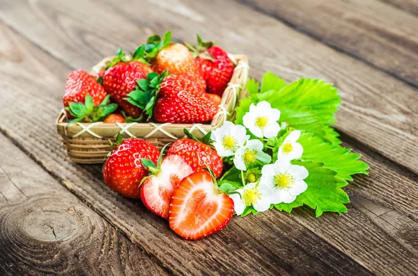 Fresas frescas en un tazón sobre una mesa de madera. — Foto de Stock