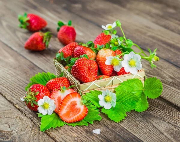 Fresas frescas en un tazón sobre una mesa de madera. — Foto de Stock