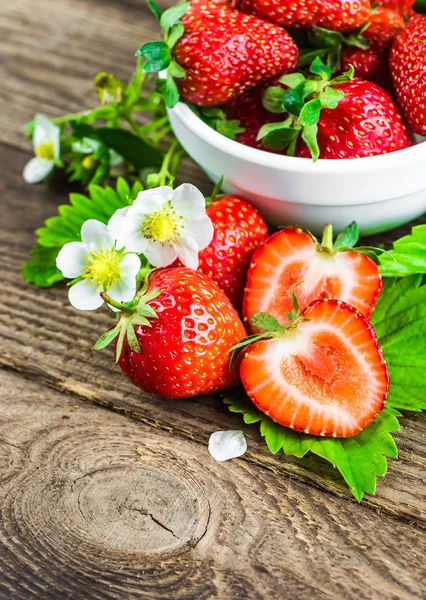 Fresas frescas en un tazón sobre una mesa de madera. — Foto de Stock