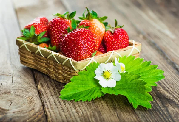 Fresas frescas en un tazón sobre una mesa de madera. — Foto de Stock