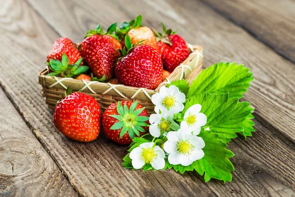 Fresh strawberries in a bowl on wooden table. — Stock Photo, Image