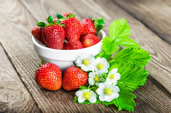 Fresas frescas en un tazón sobre una mesa de madera. — Foto de Stock