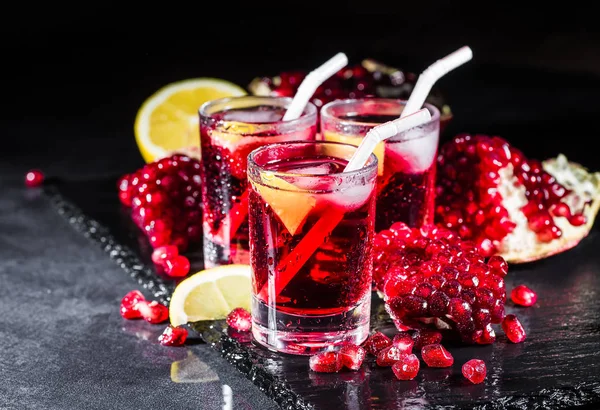 Fresh red juice cocktail with pomegranate seeds and ice