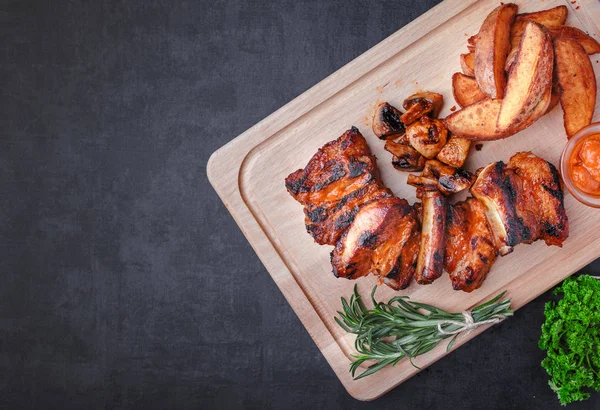 Grilled meat and vegetables on rustic wooden table