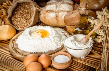 Ahşap masa arkasında pişmiş ekmek çeşitleri