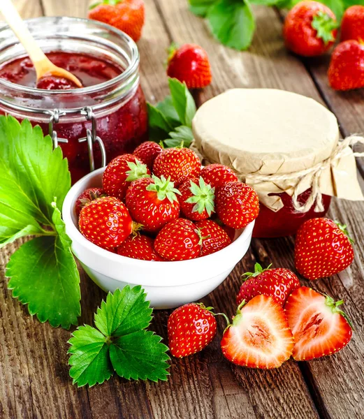 Zelfgemaakte aardbeienjam of marmelade in de glazen pot en de ba — Stockfoto