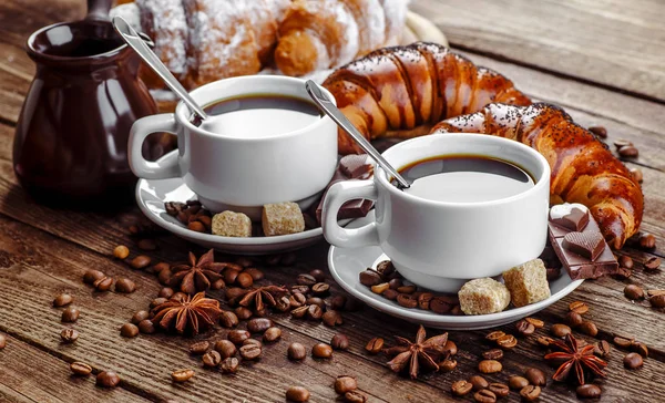 Café da manhã com croissants, folhas, tábua de corte e café preto — Fotografia de Stock