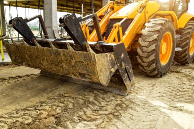 Buldozer hareket eder ve emban üzerinde toprak ve moloz yayılır