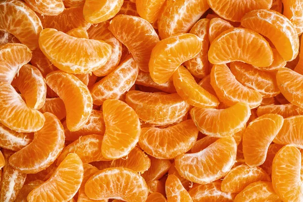 Mandarinensegmente, orangefarbene Hintergrundstruktur, flache Lage, Draufsicht — Stockfoto