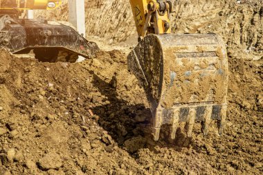 İnşaat Şantiyesinde Kazı Yapan Ekskavatör TraktörÜ Kazıyor.Şantiye ekskavatörünün yakın çekimi
