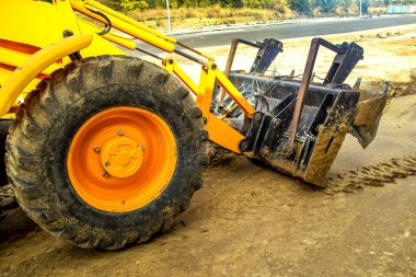 Buldozer yol kenarındaki toprak ve moloz yığınını hareket ettiriyor. İnşaat alanındaki toprak üzerinde çalışan buldozer. Yol yapım aşamasında..