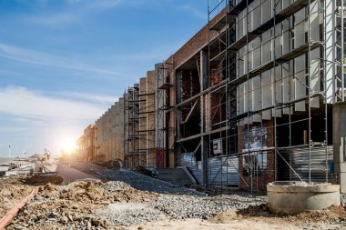 Şantiye arka planı. Vinçler ve yeni çok katlı binalar kaldırma. I.ndustrial arka plan. Mavi gökyüzüne karşı şantiye çalışmaları